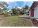 Backyard with a wooden deck, shed, and mature trees under a blue sky at 1302 5Th W St, Palmetto, FL 34221