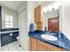 Bathroom featuring blue tiled accents, wood cabinetry, and ample natural light at 1302 5Th W St, Palmetto, FL 34221