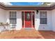 Close-up of the front door with glass window, brick patio, and charming details at 1302 5Th W St, Palmetto, FL 34221