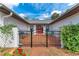 Inviting entrance with a brick patio, black metal gate, and lush landscaping at 1302 5Th W St, Palmetto, FL 34221