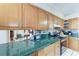 Galley kitchen with wood cabinets, green countertops and stainless steel appliances at 1302 5Th W St, Palmetto, FL 34221