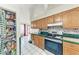 Traditional kitchen with wooden cabinetry, green countertops, and a view of the dining area at 1302 5Th W St, Palmetto, FL 34221