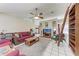 Bright living room featuring a ceiling fan, television and sliding bookcase at 1302 5Th W St, Palmetto, FL 34221