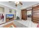 Comfortable living room featuring a ceiling fan, sliding bookcase and a television for relaxation at 1302 5Th W St, Palmetto, FL 34221