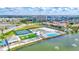 Aerial view of community amenities with tennis courts, mini golf, pool, and lake at 140 Riviera Dunes Way # 1203, Palmetto, FL 34221
