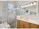 Bright bathroom showcases a glass shower, tiled walls, and vanity with ample lighting and stone countertops at 14150 Cattle Egret Pl, Lakewood Ranch, FL 34202