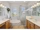 Luxurious bathroom featuring double vanities, soaking tub, and a glass-enclosed shower with pebble flooring at 14150 Cattle Egret Pl, Lakewood Ranch, FL 34202