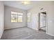 Spacious bedroom with plush carpeting, two large windows, and a doorway to a covered porch at 14150 Cattle Egret Pl, Lakewood Ranch, FL 34202
