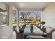 Charming covered patio with dining table, offering scenic views of the tranquil pond and lush surroundings at 14150 Cattle Egret Pl, Lakewood Ranch, FL 34202