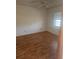 Modest bedroom with a ceiling fan and window providing natural light, complemented by wood flooring at 1472 Nantucket Rd, Venice, FL 34293