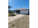 Charming single-story home featuring a one-car garage and a screened-in porch, surrounded by palm trees at 1472 Nantucket Rd, Venice, FL 34293