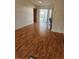 Bright living room with wood floors, ceiling fan and sliding glass door leading to outdoor patio at 1472 Nantucket Rd, Venice, FL 34293
