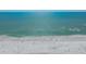 Aerial view of a vibrant beach, showcasing a sandy shoreline dotted with people and umbrellas at 148 N Polk, Sarasota, FL 34236