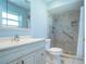 Well-lit bathroom with a walk-in shower, safety bar, and a white vanity with modern faucet at 1511 S Knollwood Dr, Bradenton, FL 34208
