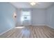 Bedroom with wood-look flooring, sconces, and a bright window at 1511 S Knollwood Dr, Bradenton, FL 34208