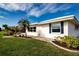 Well-maintained home exterior with lush landscaping, green lawn, and a bright blue sky at 1511 S Knollwood Dr, Bradenton, FL 34208