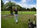 A golfer tees off on the lush green course surrounded by palm trees and a sunny sky at 1511 S Knollwood Dr, Bradenton, FL 34208