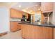 Bright kitchen features wood cabinets, black countertops and appliances, plus tile flooring at 1511 S Knollwood Dr, Bradenton, FL 34208