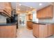 Open kitchen layout with wood cabinets, black appliances, recessed lighting, and tile floors at 1511 S Knollwood Dr, Bradenton, FL 34208