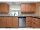 Charming kitchen with wooden cabinets, stainless steel dishwasher, and view to the dining area at 1511 S Knollwood Dr, Bradenton, FL 34208