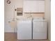 Bright laundry area with a utility sink, washer, dryer, and white cabinets at 1511 S Knollwood Dr, Bradenton, FL 34208