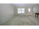 Bright living room featuring large windows, neutral wall colors, and a seamless transition between carpet and tile flooring at 1511 S Knollwood Dr, Bradenton, FL 34208