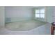 Bright living room with carpet and tile flooring, large windows, and neutral paint at 1511 S Knollwood Dr, Bradenton, FL 34208