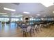 Bright meeting room with tables, chairs and TV features plentiful natural light and modern decor at 1511 S Knollwood Dr, Bradenton, FL 34208