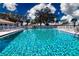 Sparkling community pool with plenty of lounge chairs for residents to enjoy under a sunny sky at 1511 S Knollwood Dr, Bradenton, FL 34208