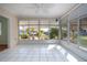 Bright sunroom with white tile floor, many windows, and ceiling fan offers relaxing views at 1511 S Knollwood Dr, Bradenton, FL 34208