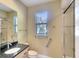 Bathroom featuring granite counters, framed mirror, window, plus a shower behind a glass door at 15403 Leven Links Pl, Lakewood Ranch, FL 34202