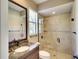 Bathroom featuring granite counters, framed mirror, window, plus a tiled shower behind a glass door at 15403 Leven Links Pl, Lakewood Ranch, FL 34202