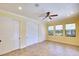 Bedroom featuring tile floors, three windows, ceiling fan, and double sliding door closets at 15403 Leven Links Pl, Lakewood Ranch, FL 34202