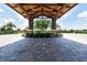 Beautiful entryway with paver driveway and a porte cochere showing well-maintained landscaping and palm trees at 15403 Leven Links Pl, Lakewood Ranch, FL 34202