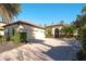 Charming home showcasing a brick driveway, a two-car garage, and tropical landscaping at 15403 Leven Links Pl, Lakewood Ranch, FL 34202