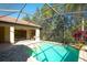 View of pool, patio, and grill area under a screened lanai with views of the surrounding property at 15403 Leven Links Pl, Lakewood Ranch, FL 34202
