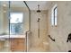 Shower area featuring stone tiles, shower bench, and hand rails at 15403 Leven Links Pl, Lakewood Ranch, FL 34202