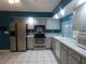 Bright kitchen with stainless steel appliances, white cabinets, and gray countertops at 1717 Alton Rd, Port Charlotte, FL 33952