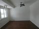 Bright living room with wood-look floors, ceiling fan and large window offering plenty of natural light at 1717 Alton Rd, Port Charlotte, FL 33952
