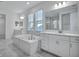 Bathroom with a large soaking tub, a walk-in shower, and dual vanities at 17703 Savory Mist Cir, Bradenton, FL 34211