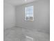 Bright bedroom with a large format tile floor and a window offering outside views at 17703 Savory Mist Cir, Bradenton, FL 34211