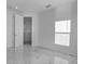 A bright bedroom featuring a large format tile floor and multiple doors at 17703 Savory Mist Cir, Bradenton, FL 34211