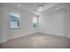 Bright bedroom with tile flooring, two windows, and a modern chandelier at 17703 Savory Mist Cir, Bradenton, FL 34211