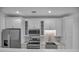 Updated kitchen featuring modern appliances, white cabinetry, and a stylish backsplash design at 17703 Savory Mist Cir, Bradenton, FL 34211
