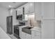 Modern kitchen featuring white cabinetry, stainless steel appliances, and stylish backsplash at 17703 Savory Mist Cir, Bradenton, FL 34211
