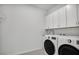 Clean laundry room with white cabinets and modern washer and dryer at 17703 Savory Mist Cir, Bradenton, FL 34211