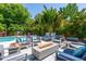 Secluded backyard patio area with comfortable seating, a modern gas fire pit, and tropical landscaping at 2283 Arlington St, Sarasota, FL 34239