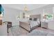 Bright bedroom with a queen bed, a window, a chandelier, and an accent chair at 2283 Arlington St, Sarasota, FL 34239