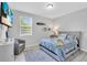 Bright bedroom with a queen bed, nautical decor, a gray accent chair, and a large window at 2283 Arlington St, Sarasota, FL 34239