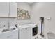 Well-lit laundry room with modern washer, dryer, sink, and ample cabinet space at 2283 Arlington St, Sarasota, FL 34239
